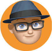 A cartoon or emoji style icon representing Kevin Double on an orange circle. Kevin's emoji is wearing a blue trilby type hat and dark rimmed glasses.